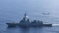 Un avion de surveillance maritime Falcon F200 Gardian survole la frégate australienne Brisbane