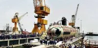 Des ingénieurs et ouvriers du chant naval Mazagon Dock Ltd. de Mumbai lors de la sortie du hall de construction du premier sous-marin Scorpene indien