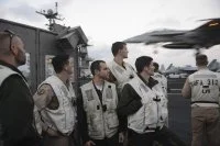 Des pilotes du Charles de French assistent à l'appontage d'avions depuis la plateforme de signalisation du porte-avions USS Harry S. Truman