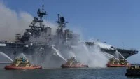 Des bâteaux-pompes refroidissent la coque du navire amphibie américain USS Bonhomme Richard