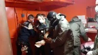 Un membre de l'équipage du Forbin s'équipe d'une combinaison NRBC (Nucléaires, radiologiques, biologiques et chimiques)