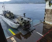 Des véhicules de l'armée de terre embarquent sur un chaland de transport de matériel (CTM)