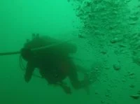 Un plongeur-démineur descend le long de la ligne de vie