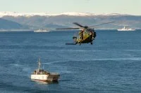 Un hélicoptère survole un chaland de transport de matériel