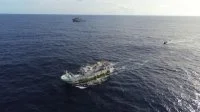Le bâtiment de soutien Bougainville et un bateau de pêche