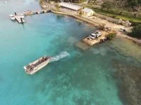 Une embarcation du Bougainville quitte un quai sur l'île des Pins